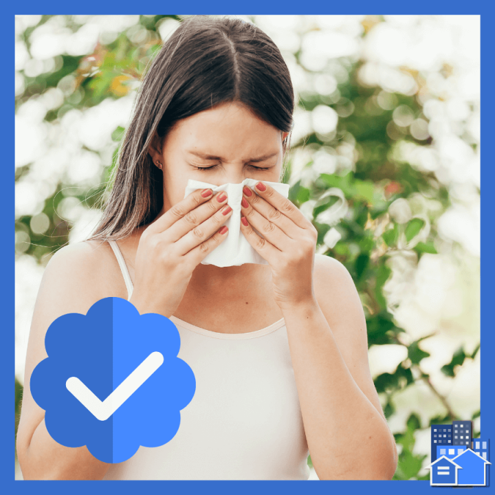 A woman blowing her nose due to allergies