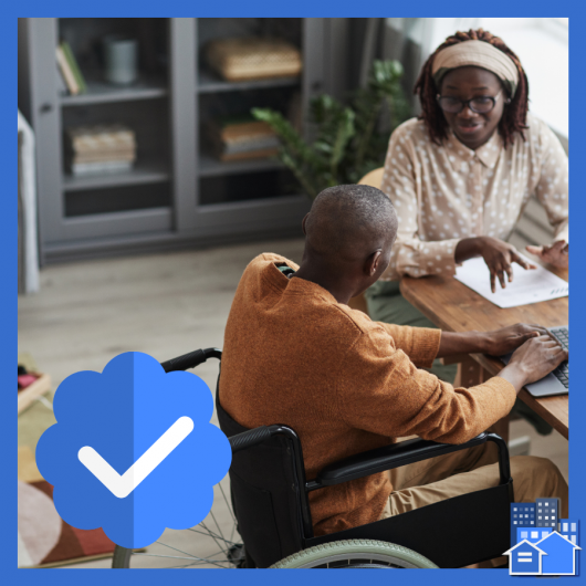 A man and a woman sitting at a table with a man in a wheel chair verifying the need for a subsidized accessible unit.